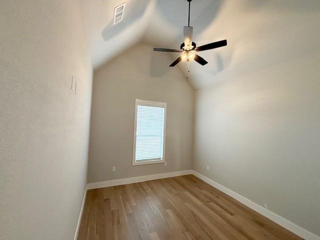 7919 Via Roma Ave, Springdale, AR 72762 - spare room featuring wood finished floors, ceiling fan, lofted ceiling, and baseboards