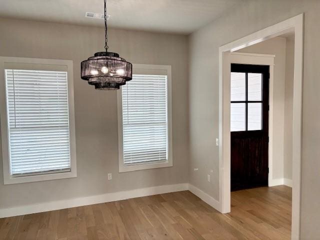 7919 Via Roma Ave, Springdale, AR 72762 - unfurnished dining area with a chandelier, baseboards, and wood finished floors