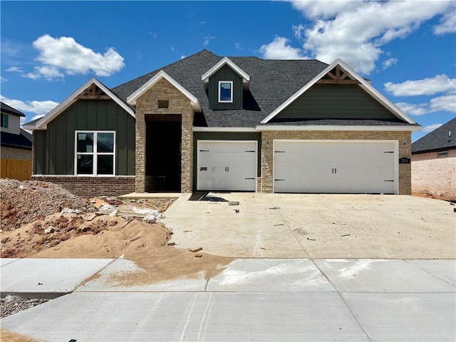 2209 Bergman St, Pea Ridge, AR 72751 - view of front facade featuring driveway, board and batten siding, brick siding, a garage, and a shingled roof