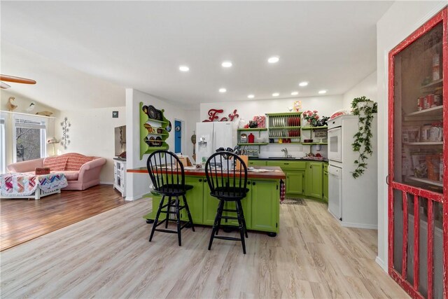 30 Strichen Dr, Bella Vista, AR 72715 - kitchen with a breakfast bar, light wood-style flooring, a center island, green cabinetry, and a sink