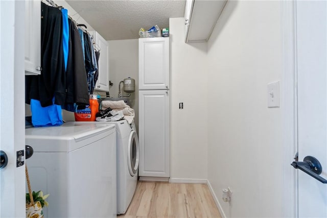 30 Strichen Dr, Bella Vista, AR 72715 - laundry area featuring light wood-type flooring, a textured ceiling, washing machine and dryer, baseboards, and cabinet space