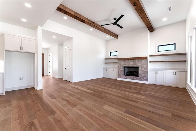 3601 Beaverhead, Bentonville, AR 72712 - unfurnished living room featuring recessed lighting, a tiled fireplace, beamed ceiling, ceiling fan, and wood finished floors