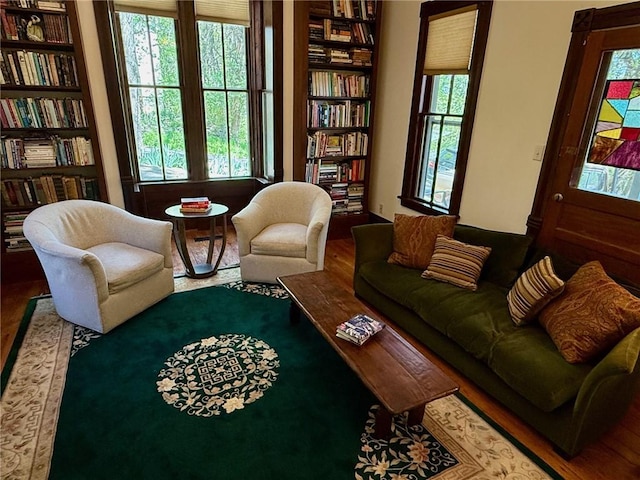 living area featuring built in features and wood finished floors