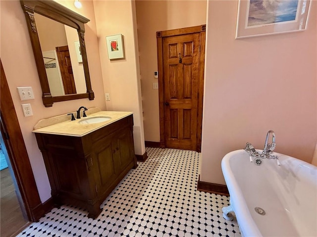 full bath with a soaking tub, tile patterned floors, baseboards, and vanity