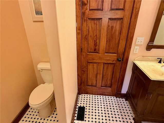 bathroom featuring toilet, baseboards, vanity, and tile patterned flooring