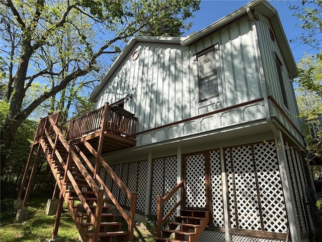 back of property with a deck and stairway