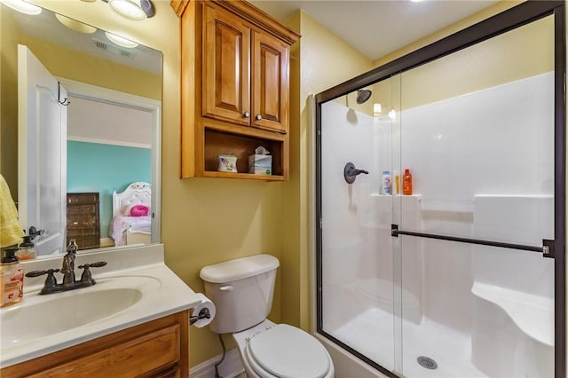 bathroom with toilet, vanity, visible vents, and a stall shower