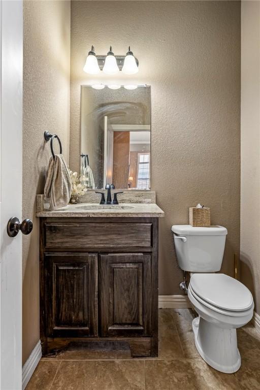 4502 SW Alfalfa Ave, Bentonville, AR 72713 - bathroom featuring vanity, a textured wall, and tile patterned flooring