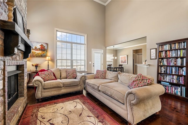 4502 SW Alfalfa Ave, Bentonville, AR 72713 - living area featuring a fireplace, a towering ceiling, crown molding, hardwood / wood-style flooring, and a chandelier