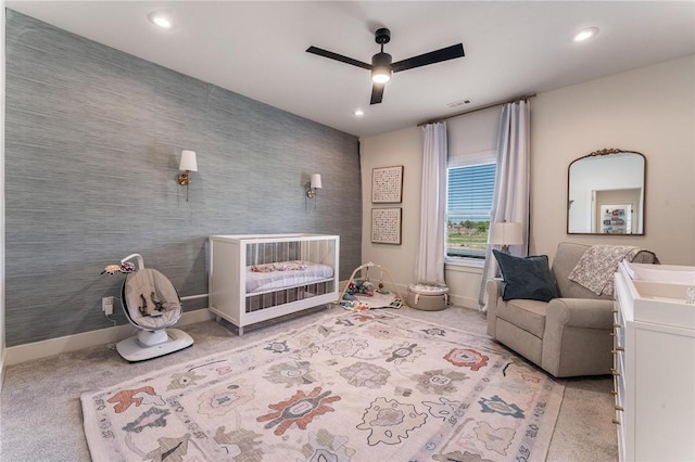 bedroom with recessed lighting, a nursery area, carpet floors, and baseboards
