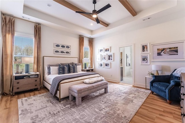 bedroom with beamed ceiling, light wood-type flooring, and visible vents