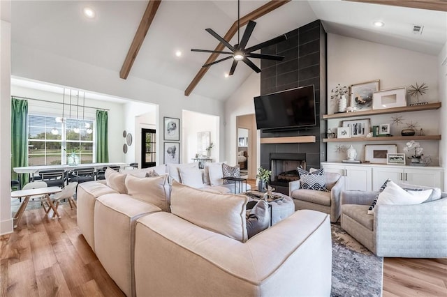 living room with recessed lighting, a tile fireplace, light wood-type flooring, high vaulted ceiling, and ceiling fan
