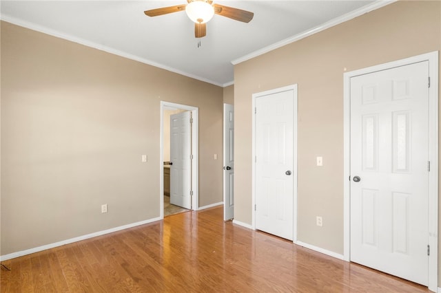 unfurnished bedroom with baseboards, a ceiling fan, wood finished floors, and ornamental molding