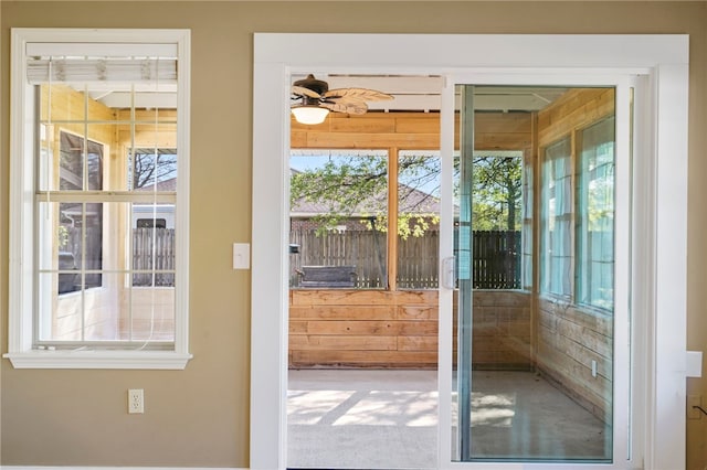 doorway to outside featuring wooden walls and a wealth of natural light