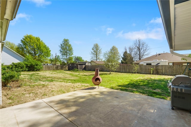 view of patio / terrace with an outdoor structure, a storage unit, area for grilling, and a fenced backyard