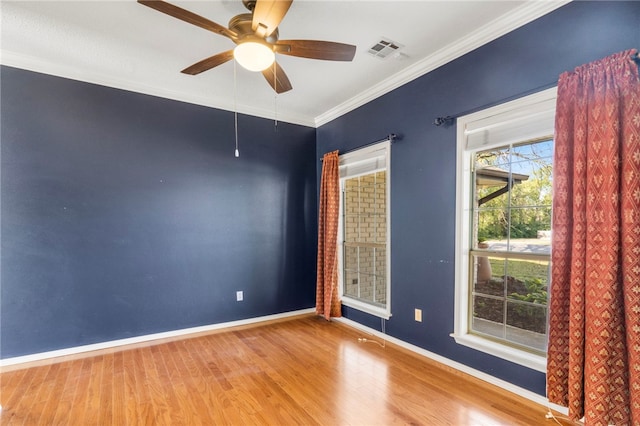 spare room featuring baseboards, wood finished floors, and visible vents