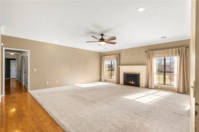 503 Oakwood St, Lowell, AR 72745 - unfurnished living room with a ceiling fan, healthy amount of natural light, a tiled fireplace, ornamental molding, and recessed lighting