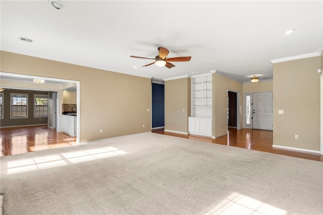503 Oakwood St, Lowell, AR 72745 - unfurnished living room featuring carpet, crown molding, a ceiling fan, baseboards, and built in features