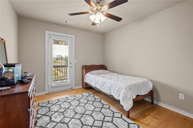 bedroom with visible vents, light wood finished floors, baseboards, and access to outside