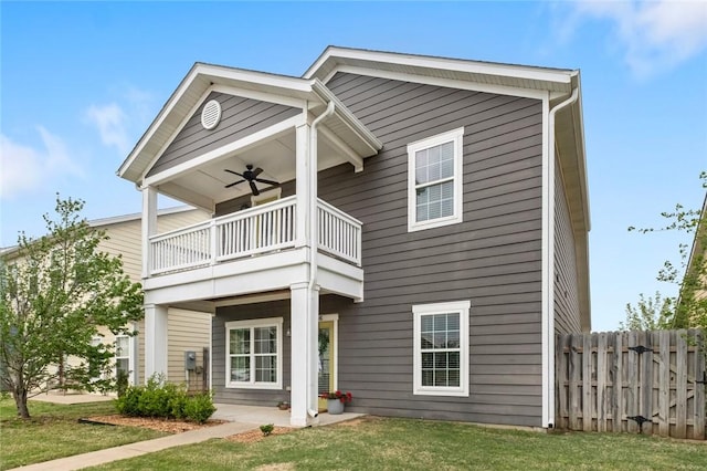 view of front of property with ceiling fan, fence, a balcony, a front yard, and a patio area