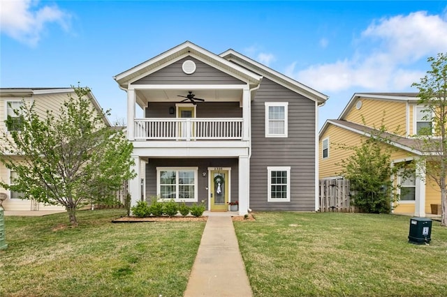 view of front of property with fence, a ceiling fan, a front lawn, and a balcony