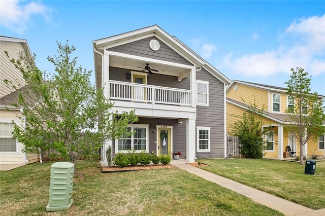 view of front of property featuring ceiling fan, a balcony, and a front yard