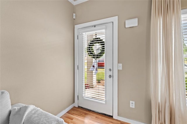 doorway featuring light wood-type flooring and baseboards
