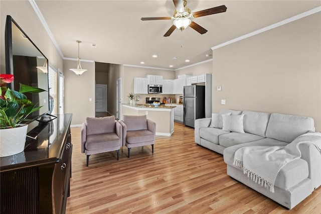 living area featuring a ceiling fan, recessed lighting, ornamental molding, and light wood-style floors
