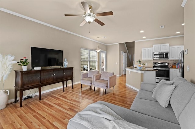 living room with a ceiling fan, baseboards, light wood-style floors, ornamental molding, and recessed lighting