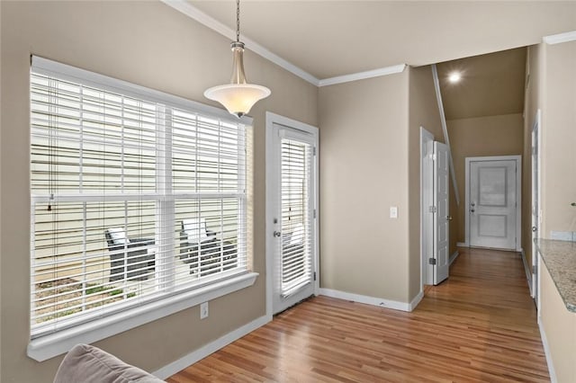 unfurnished dining area with crown molding, baseboards, and wood finished floors