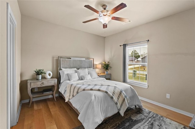 bedroom with visible vents, light wood-style floors, ceiling fan, and baseboards