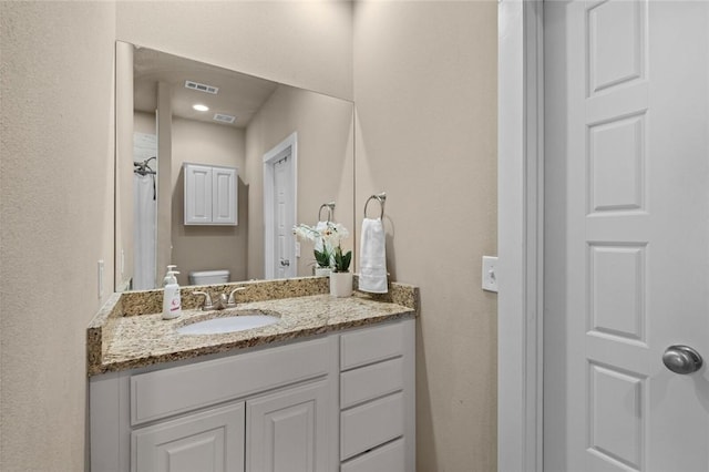 bathroom with toilet, visible vents, curtained shower, and vanity