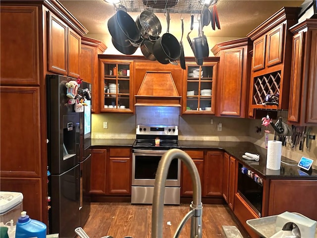 1 Binham Ln, Bella Vista, AR 72715 - kitchen with black refrigerator with ice dispenser, stainless steel electric range oven, custom range hood, dark countertops, and dark wood finished floors