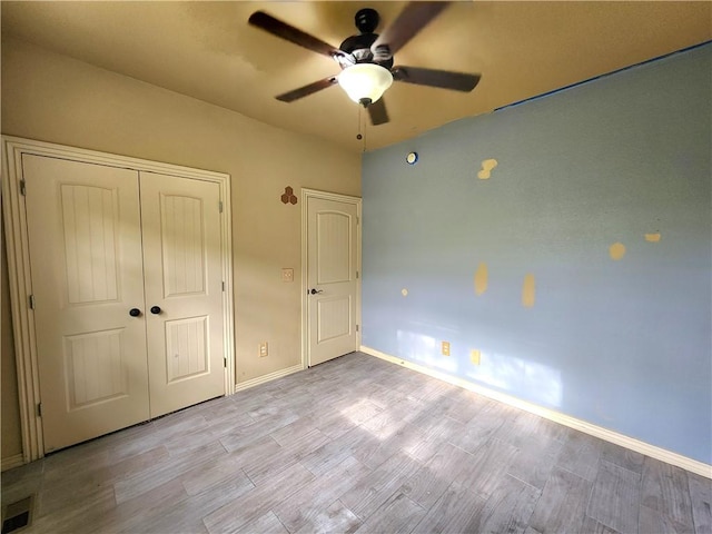 1 Binham Ln, Bella Vista, AR 72715 - unfurnished bedroom with light wood finished floors, a closet, baseboards, and a ceiling fan
