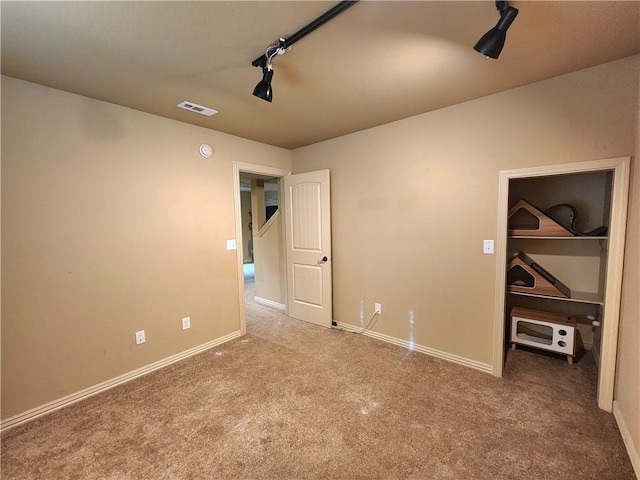 1 Binham Ln, Bella Vista, AR 72715 - unfurnished bedroom featuring carpet floors, a spacious closet, baseboards, rail lighting, and a closet