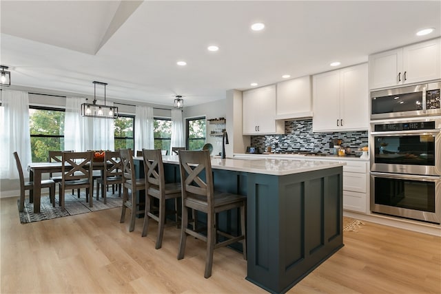 22 Cromarty Ln, Bella Vista, AR 72715 - kitchen with stainless steel appliances, white cabinetry, healthy amount of natural light, and recessed lighting