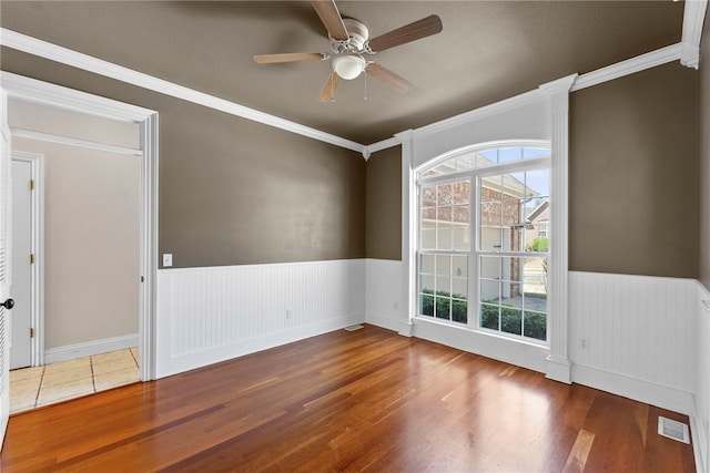 3902 NE Cadbury Ave, Bentonville, AR 72712 - empty room featuring wood finished floors, healthy amount of natural light, ceiling fan, a wainscoted wall, and ornamental molding