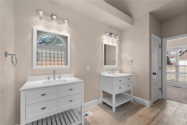 3902 NE Cadbury Ave, Bentonville, AR 72712 - bathroom featuring two vanities, healthy amount of natural light, and baseboards