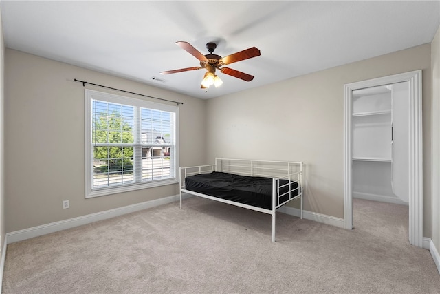3902 NE Cadbury Ave, Bentonville, AR 72712 - carpeted bedroom featuring baseboards, a walk in closet, and a ceiling fan