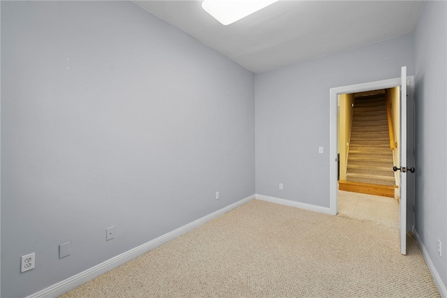 3902 NE Cadbury Ave, Bentonville, AR 72712 - spare room with light colored carpet, baseboards, and stairway