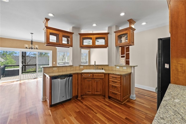 3902 NE Cadbury Ave, Bentonville, AR 72712 - kitchen with stainless steel dishwasher, a sink, freestanding refrigerator, dark wood finished floors, and brown cabinets