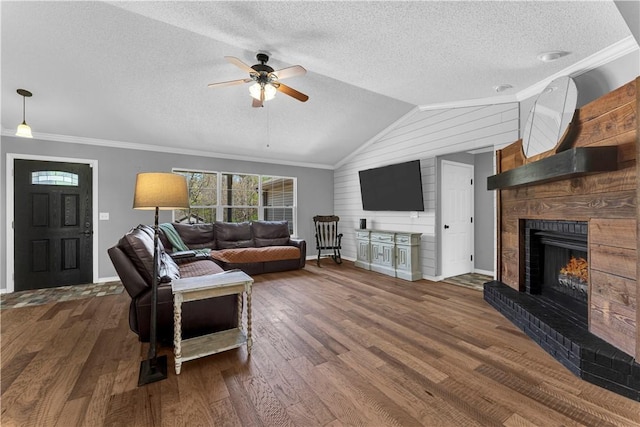 living room featuring a ceiling fan, a fireplace, baseboards, a textured ceiling, and vaulted ceiling
