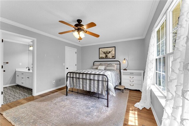 bedroom featuring wood finished floors, crown molding, baseboards, and ceiling fan