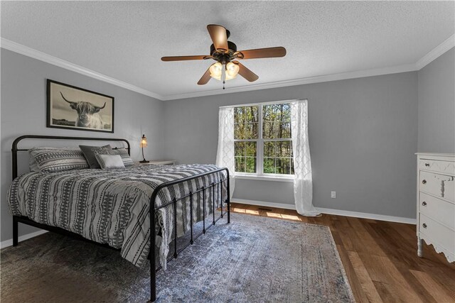 bedroom featuring ornamental molding, wood finished floors, baseboards, a textured ceiling, and a ceiling fan