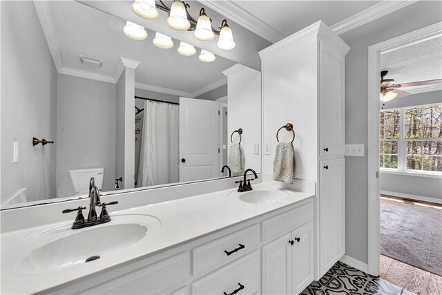full bath featuring ceiling fan, crown molding, double vanity, and baseboards