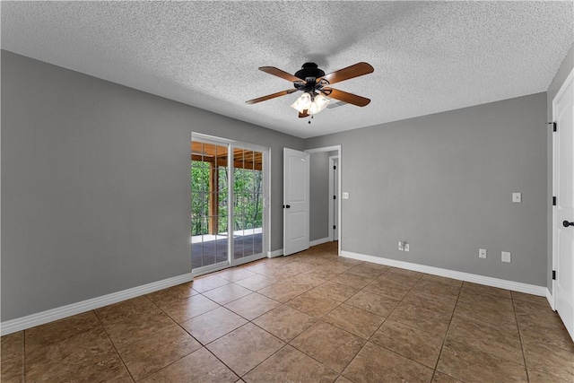 tiled spare room featuring ceiling fan, a textured ceiling, and baseboards