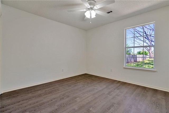 1762 Oxford Pl, Springdale, AR 72764 - spare room featuring dark wood-type flooring, baseboards, ceiling fan, and a textured ceiling