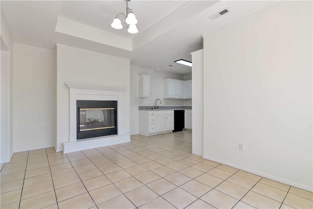 1740 Oxford Pl, Springdale, AR 72764 - unfurnished living room featuring a chandelier, light tile patterned floors, a raised ceiling, a sink, and a glass covered fireplace