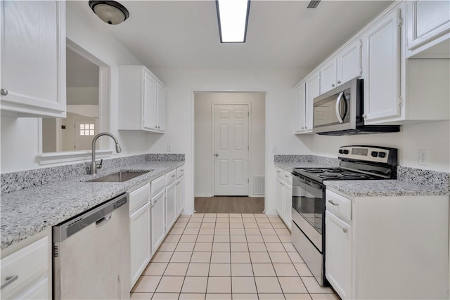 1765 Oxford Pl, Springdale, AR 72764 - kitchen featuring stainless steel appliances, a sink, white cabinetry, light tile patterned floors, and light stone counters