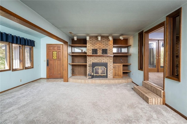 19584 Neills Bluff Rd, Springdale, AR 72764 - unfurnished living room with carpet, baseboards, track lighting, and a fireplace